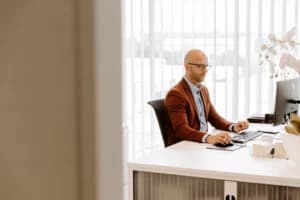 Jeroen zit te werken achter zijn computer aan zijn bureau