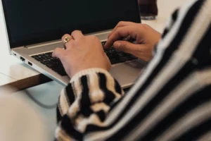 Close up van handen die iets aan het typen zijn op een laptop