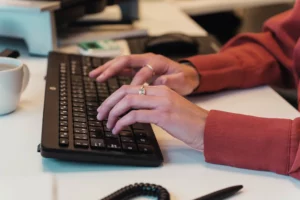 Close up van handen die op een klavier aan het typen zijn