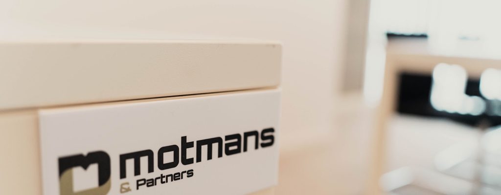 plakkaat met logo van Motmans op de muur geplakt