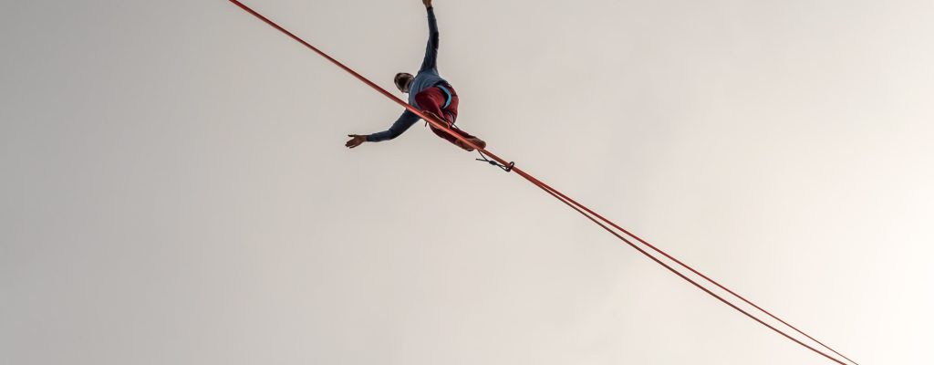 Een man balanceert op een strak touw.